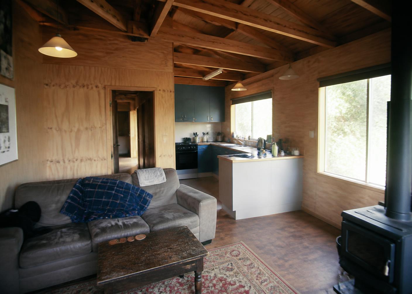 Plywood-lined cottage interior with exposed timber beams
