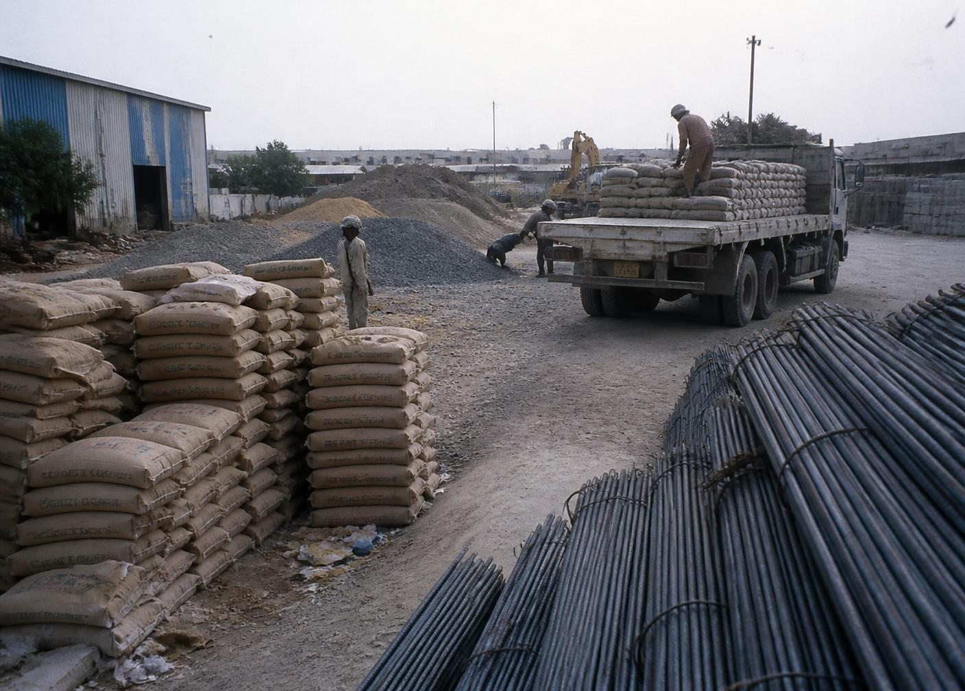 Stone blocks, timber, cement and clay roof tiles stacked in a supply yard